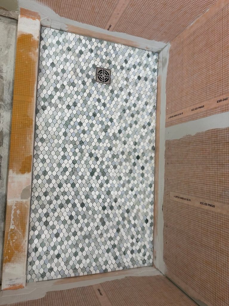White Marble-Look Shower With an Arabesque Mosaic Floor