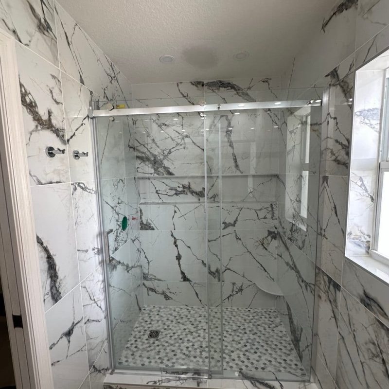 White Marble-Look Shower With an Arabesque Mosaic Floor