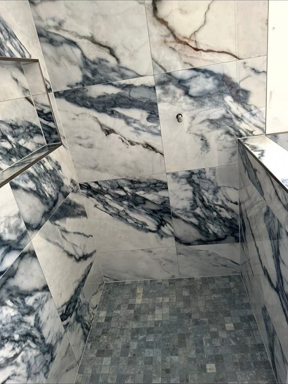 Blue-Vein Marble-Look Shower With a Knee Wall