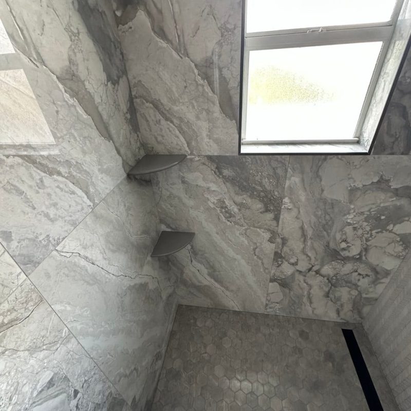 Gray Marble-Look Shower With a Chevron Mosaic Wall