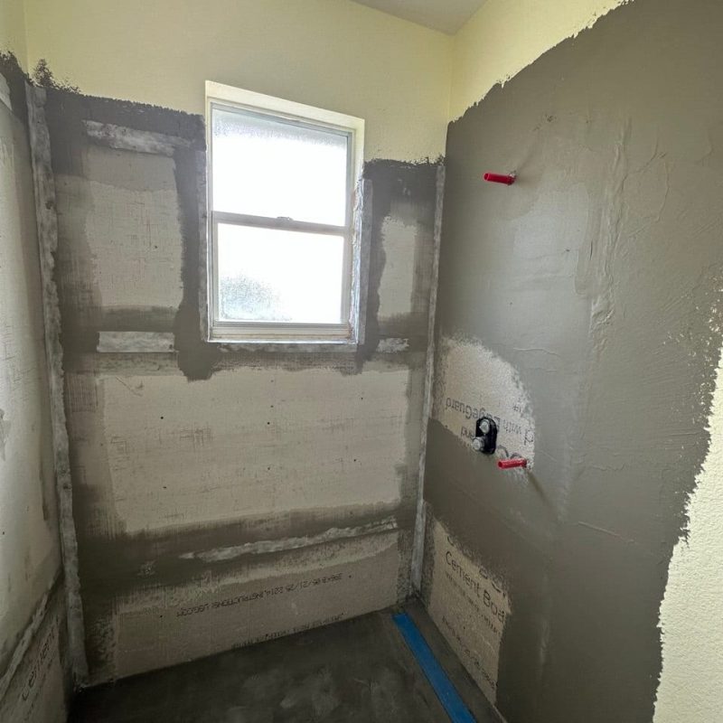 Gray Marble-Look Shower With a Chevron Mosaic Wall