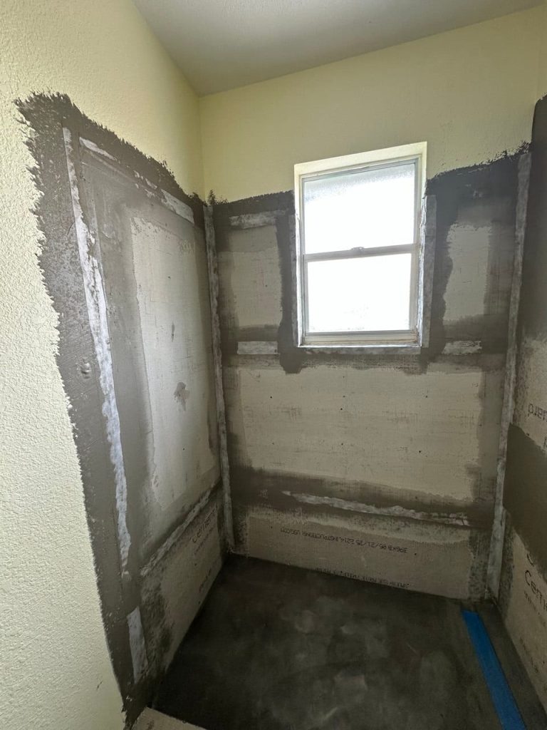 Gray Marble-Look Shower With a Chevron Mosaic Wall