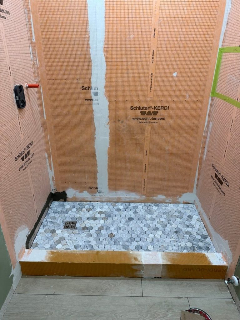 Marble-Look Shower With a Hexagon Mosaic Floor